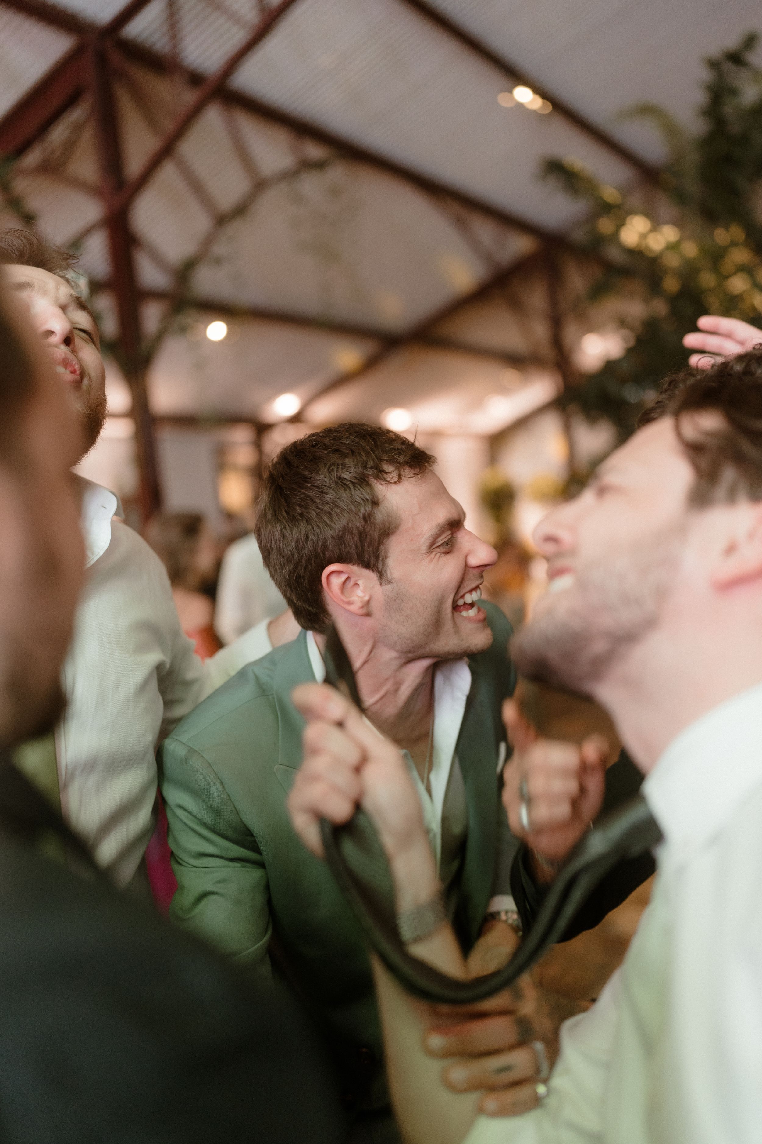 Group of friends laughing and celebrating at indoor event.