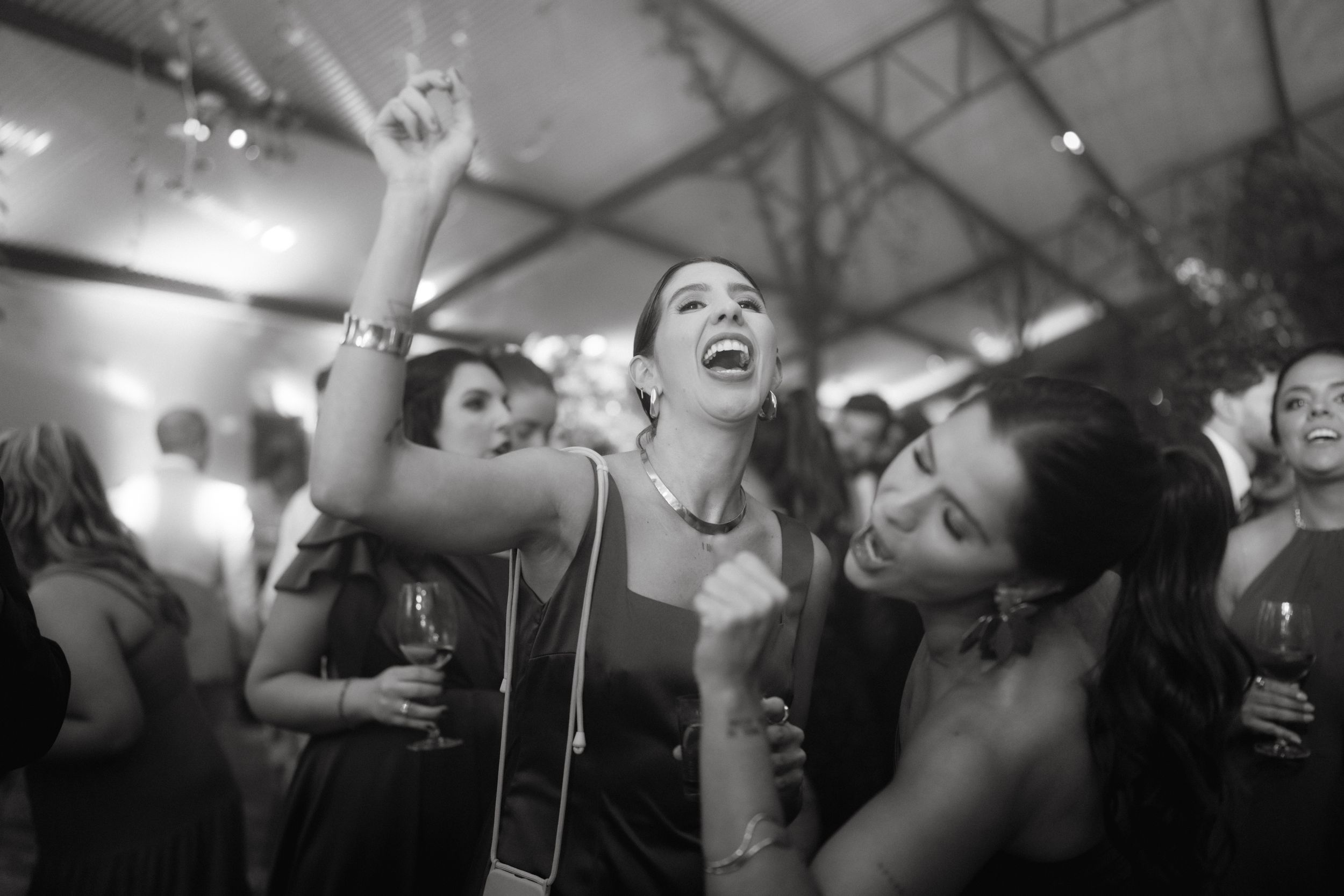 Black and white photo of people dancing energetically at a party.