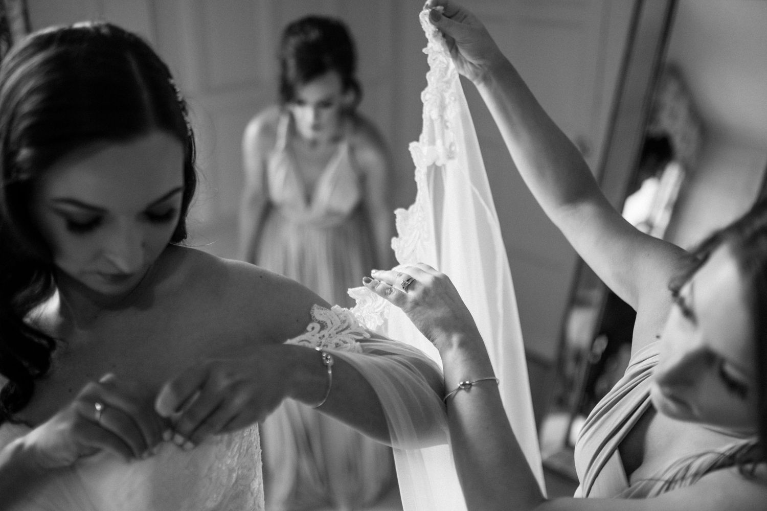 Elegant black and white photograph capturing a tender moment of wedding dress preparations at Westin Nova Scotian, Halifax.
