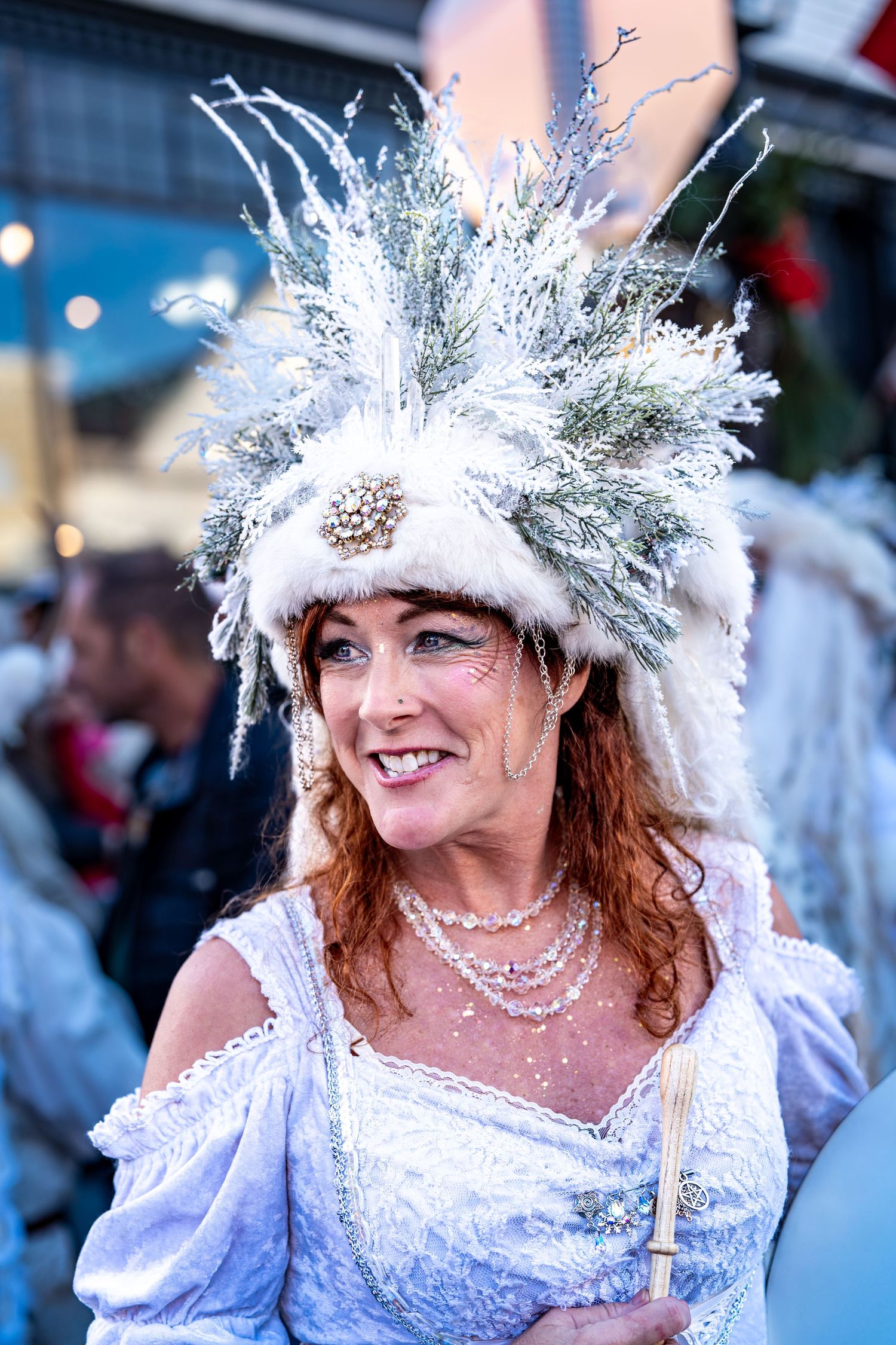 A festive winter scene featuring an elaborate white and silver costume with crystalline headpiece.