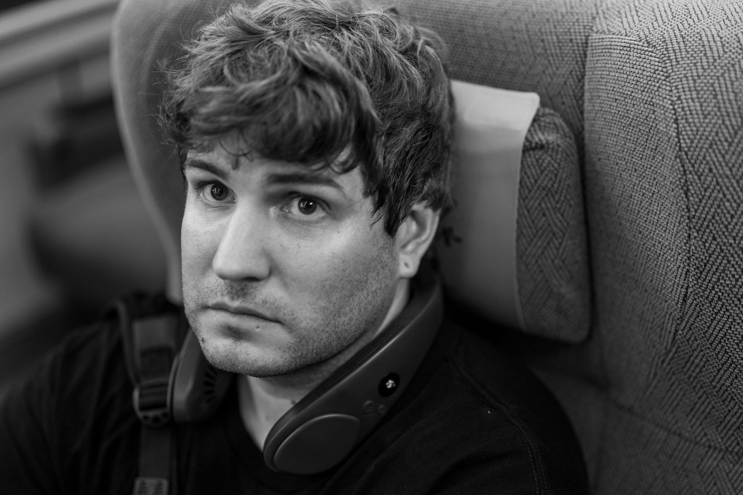 A black and white portrait showing a thoughtful expression against a grey background.