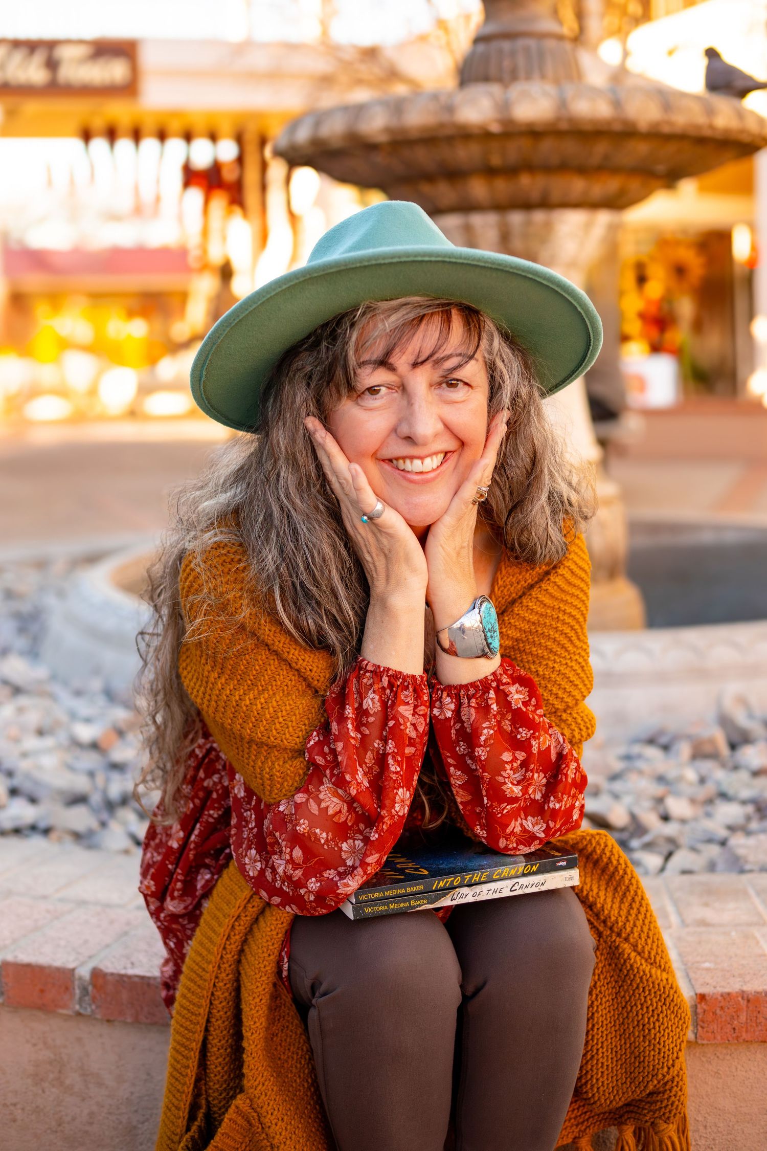 Candid lifestyle photo with orange cardigan and patterned dress on stone steps.