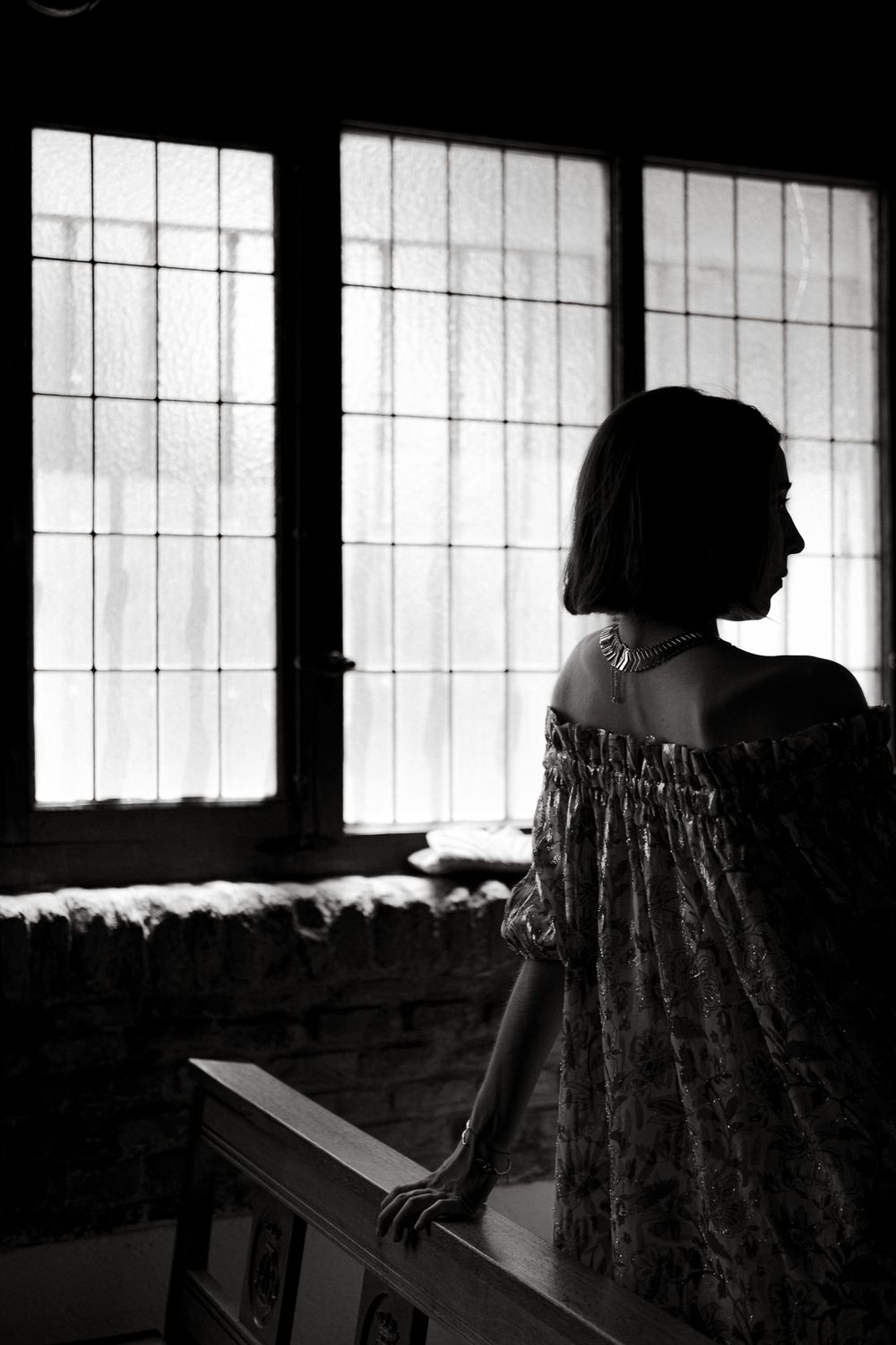 Artistic black and white silhouette against window panes in historic building.