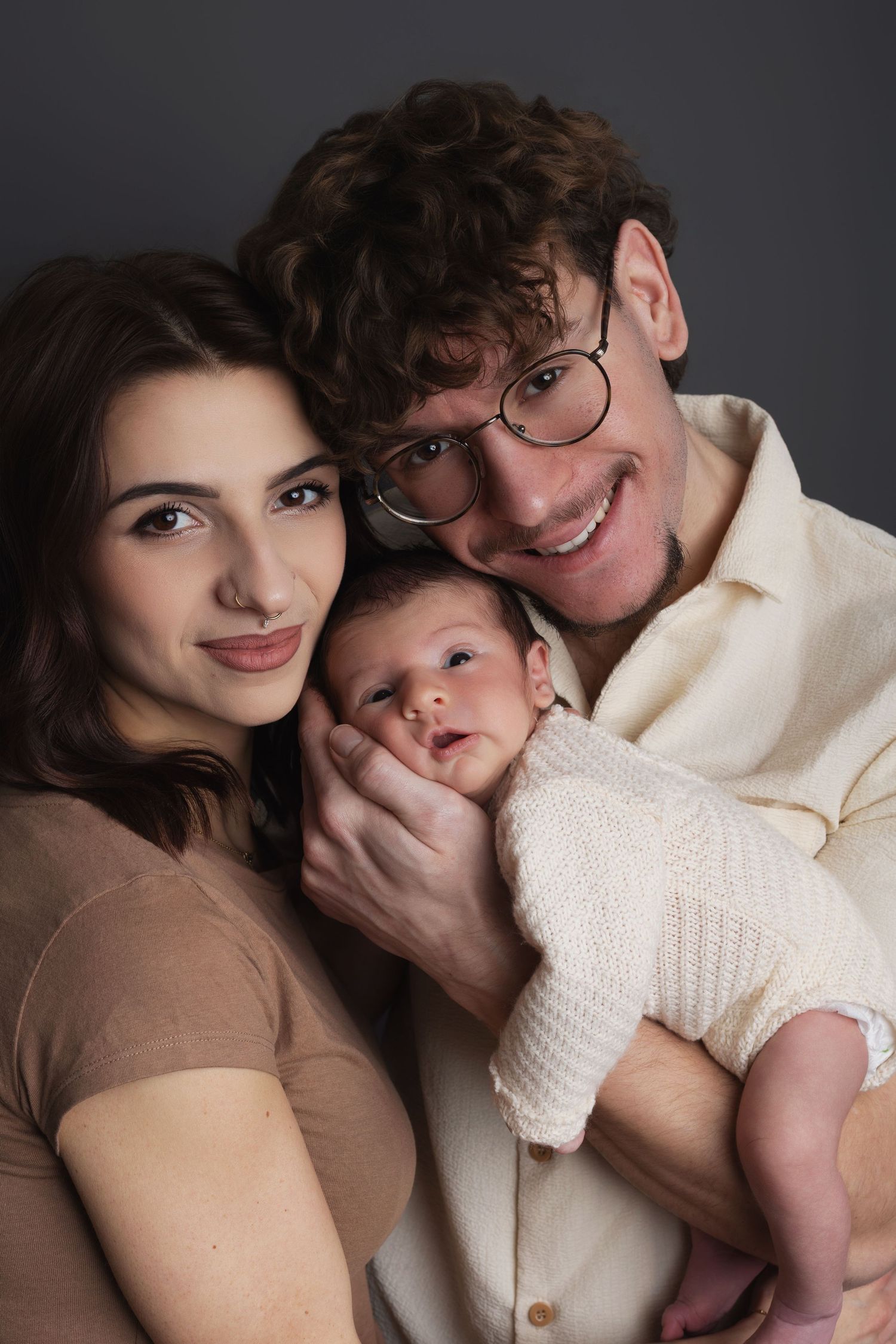 A joyful family portrait against a light blue background wearing coordinated black and white patterned outfits.