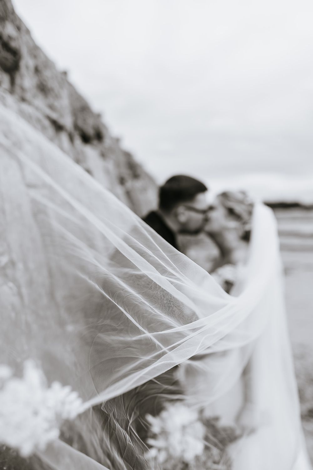Moray wedding photographer Beth Sutton captures flowing white wedding veil catching the wind in dramatic black and white photograph.
