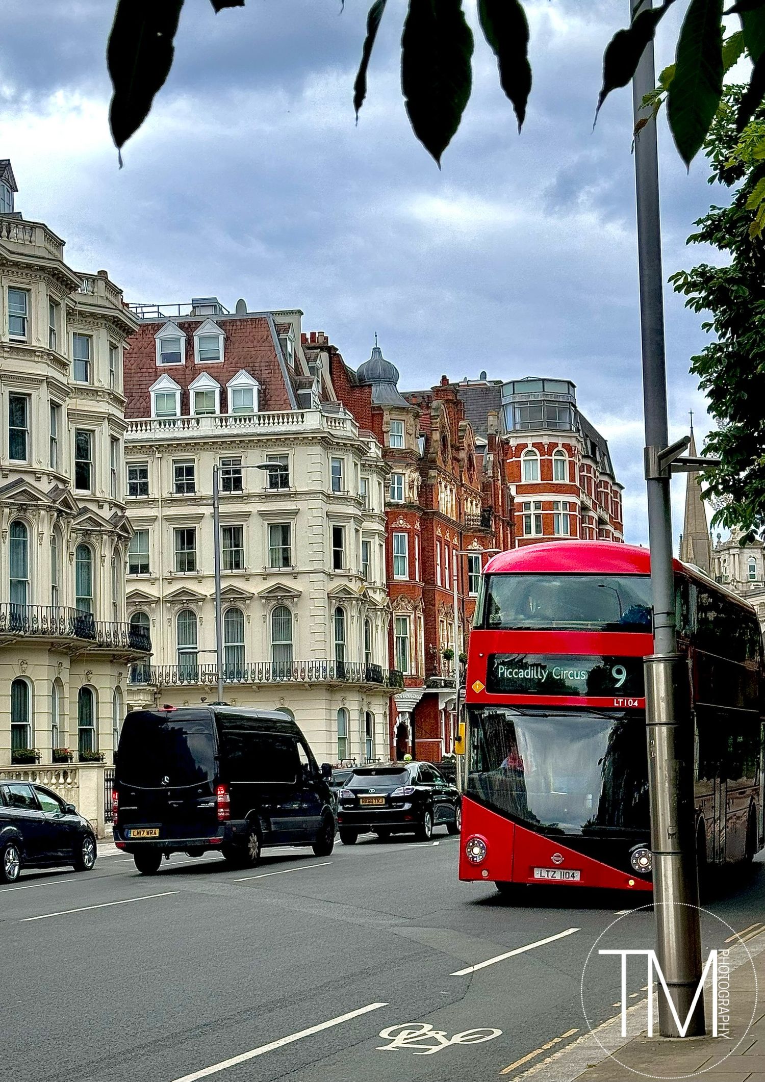Classic London street scene with red double-decker bus and Victorian architecture.