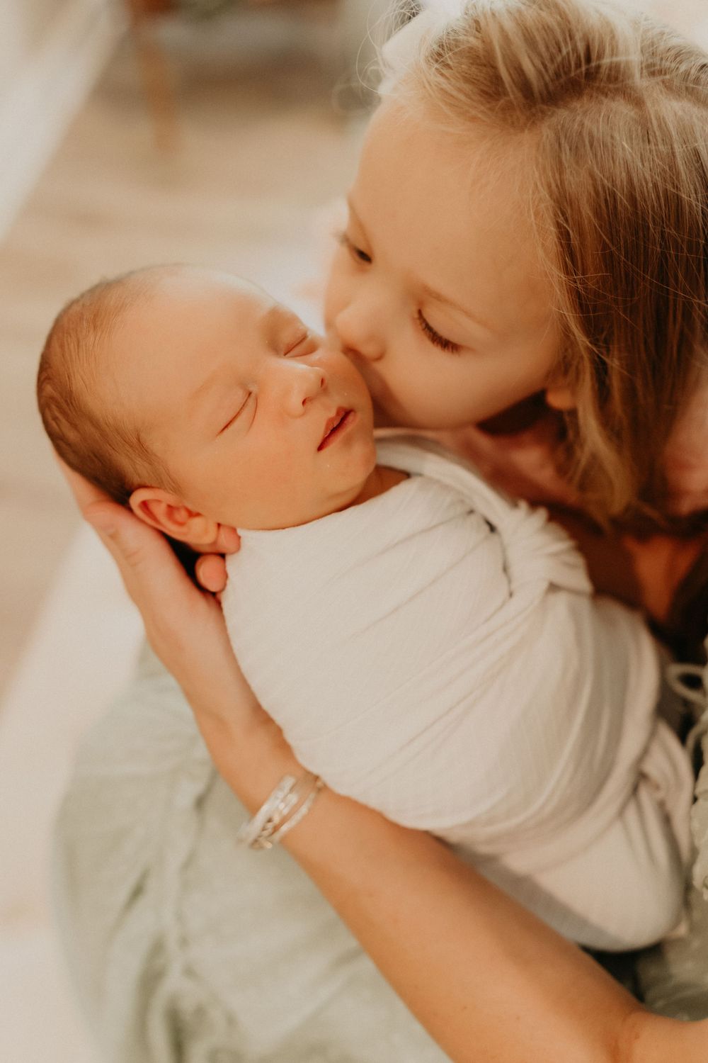 Newborn baby sleeping peacefully on a soft blanket, captured in a cozy indoor photoshoot.