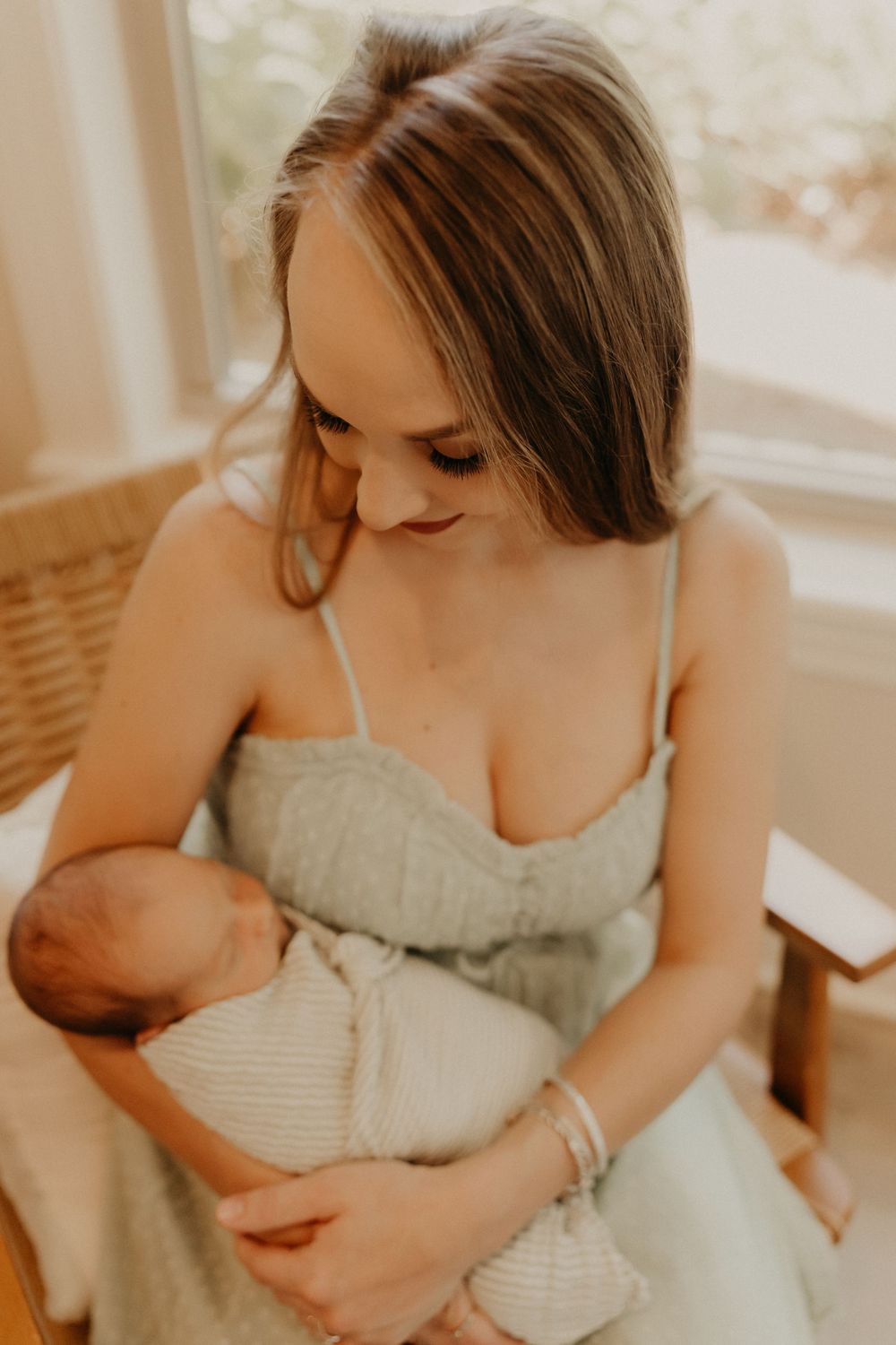 Newborn baby sleeping peacefully on a soft blanket, captured in a cozy indoor photoshoot.