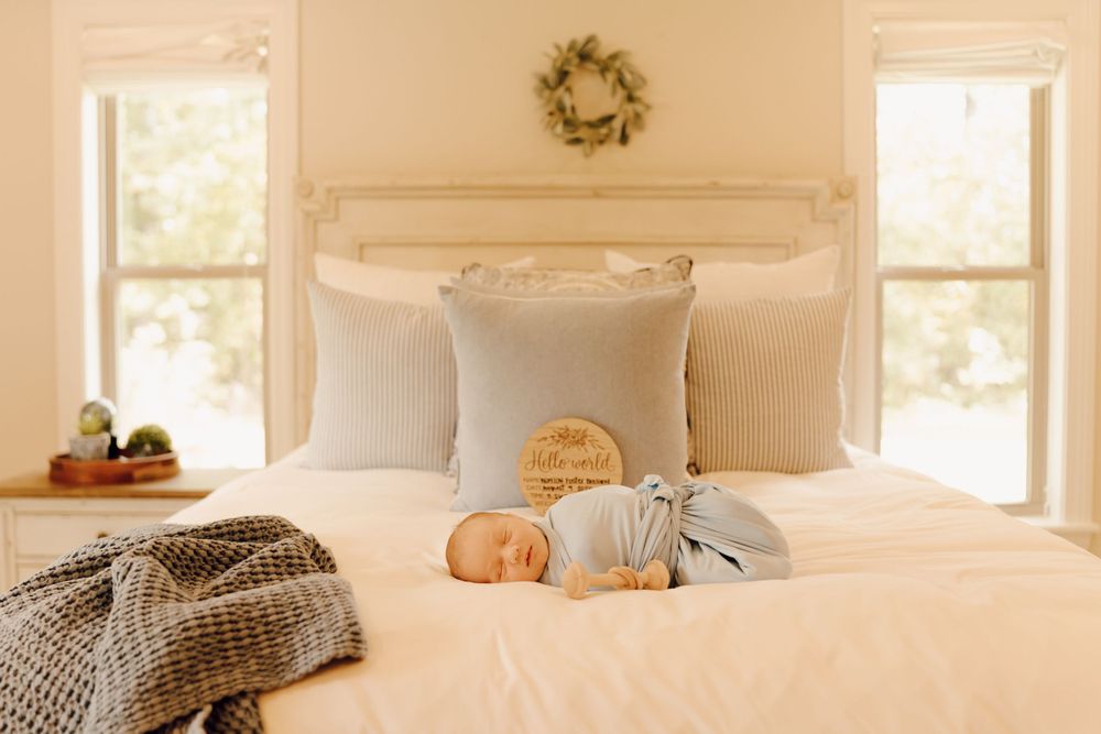 Newborn baby sleeping peacefully on a soft blanket, captured in a cozy indoor photoshoot.