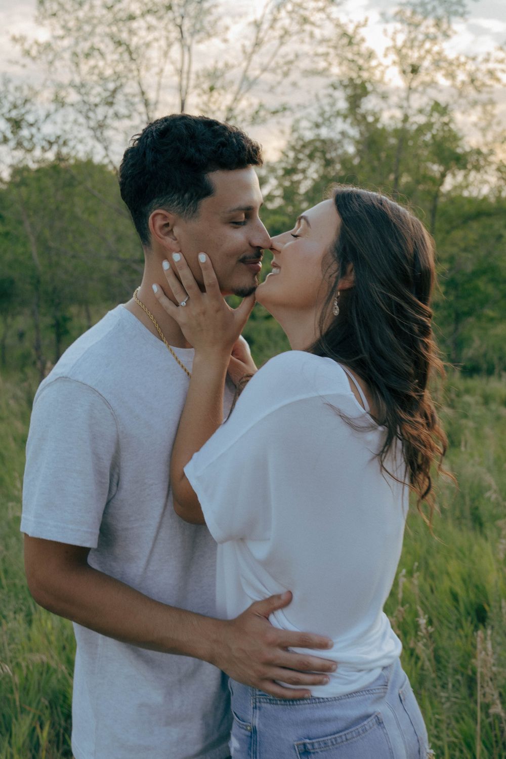 Romantic outdoor portrait of couple embracing in natural lighting.