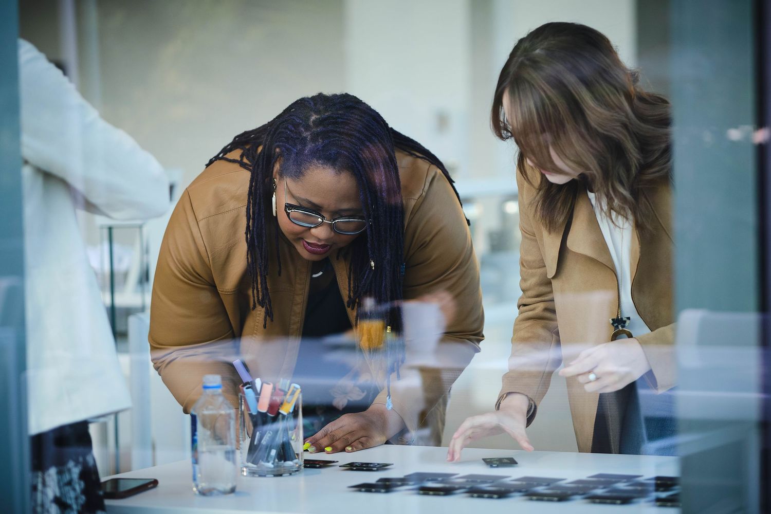 Colleagues collaborating over documents spread on a modern office table.