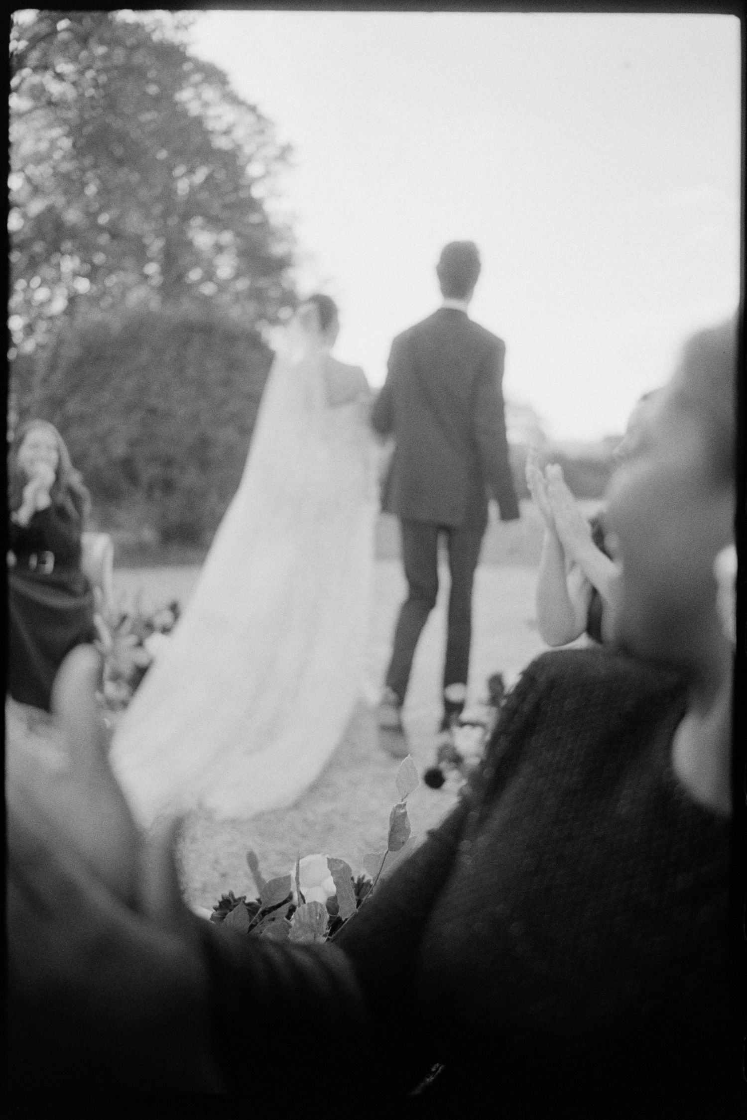 The bride and groom are walking down the aisle holding hands.