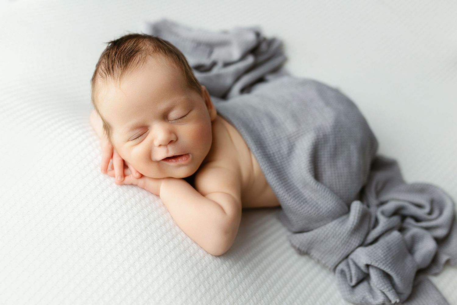 Newborn baby boy doing a chin-on-hands pose with a grin. - Greenville, SC newborn photographer - Easley, SC newborn photographer.