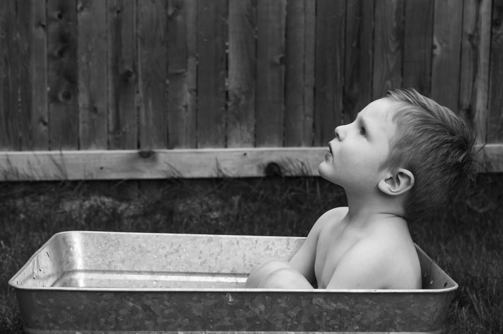 Black and white photo of toddler in outdoor milk bath session | Broomfield Family Photographer