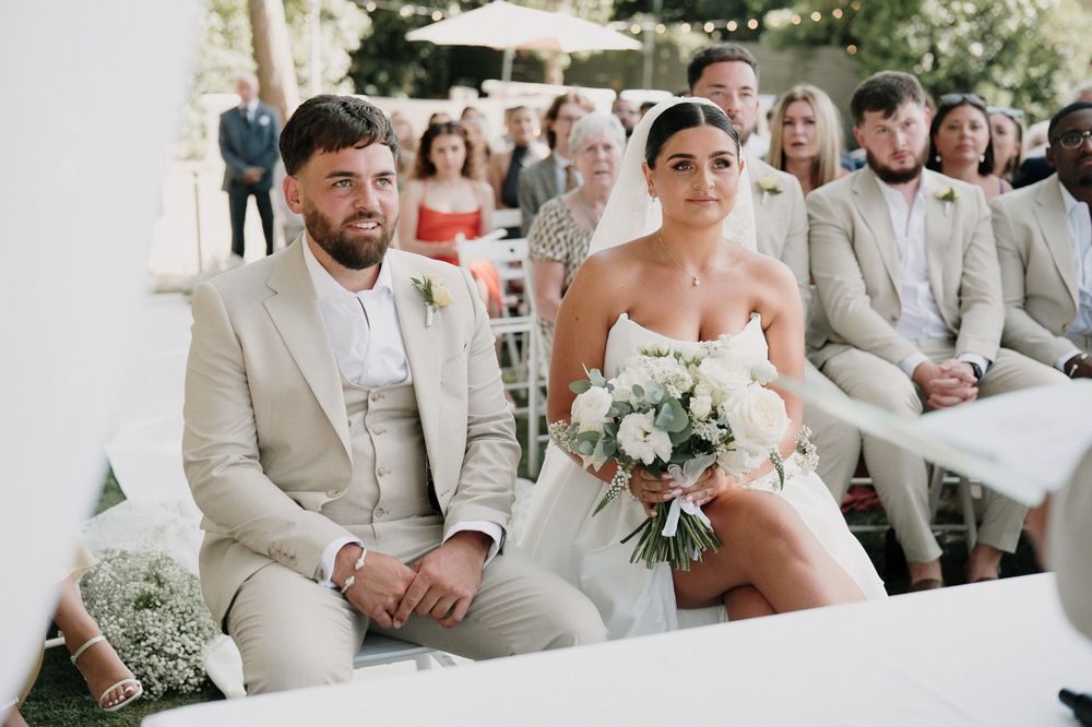 The newlyweds sit during the civil ceremony in the park of Villa Nobel Sanremo.