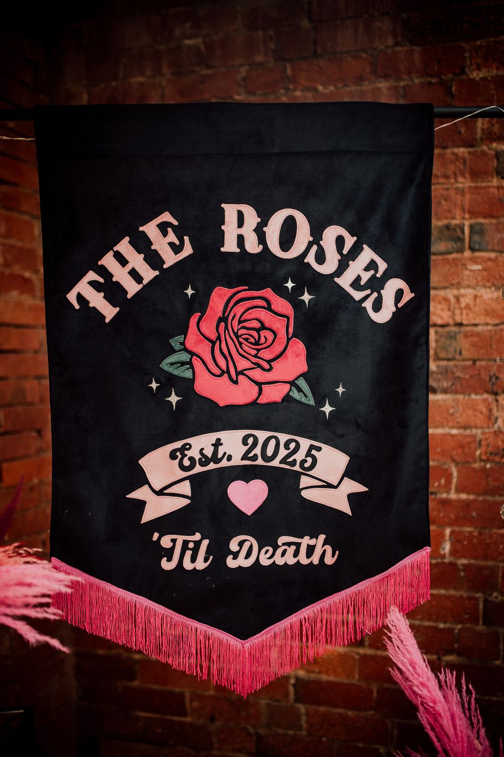 Black banner with pink rose design and text reading 'Til Death Est. 2025'.