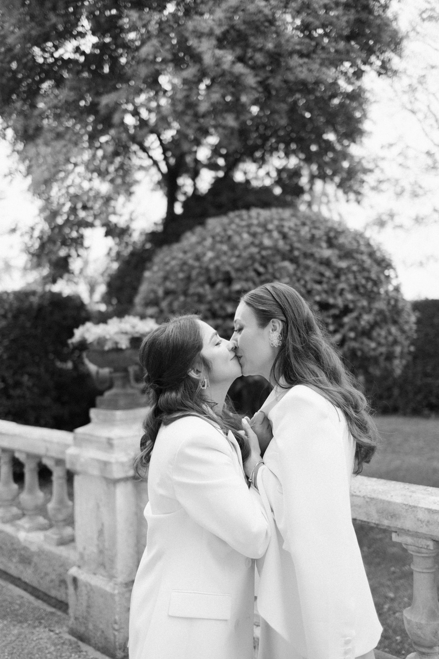 Brides kiss each other during their first look