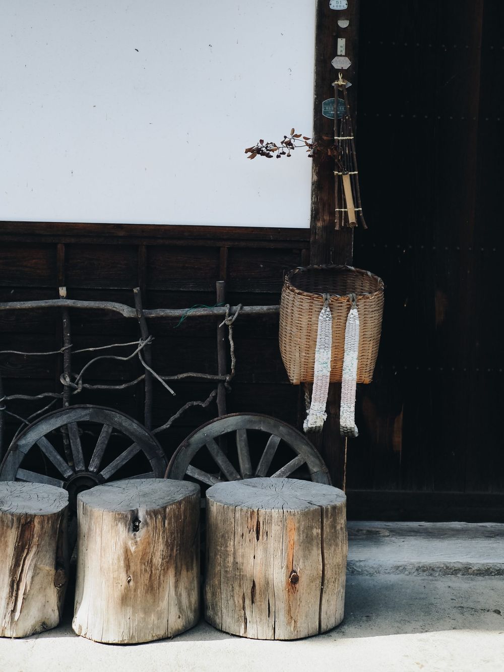 Rustic Japanese scene with wooden logs and traditional lantern decorations against dark walls.