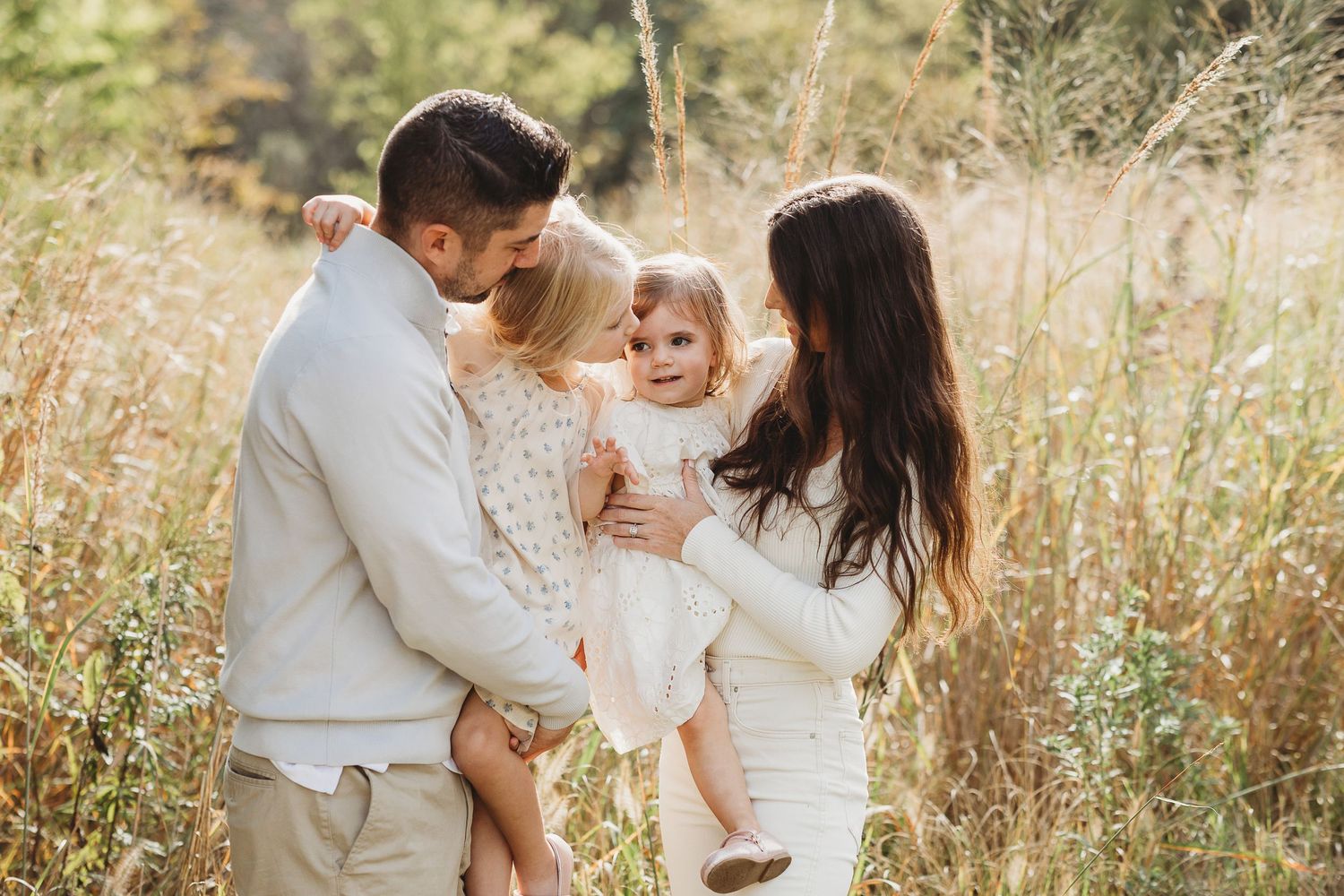 A tender family moment captured in soft beige tones with delicate lace dresses and dried pampas grass decor.