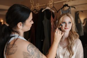 A series of candid wedding preparation moments showing the bride and bridesmaids getting ready in a warmly lit room.