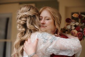 A couple embraces in an intimate dance moment, with the bride wearing a delicate lace-sleeved wedding gown.