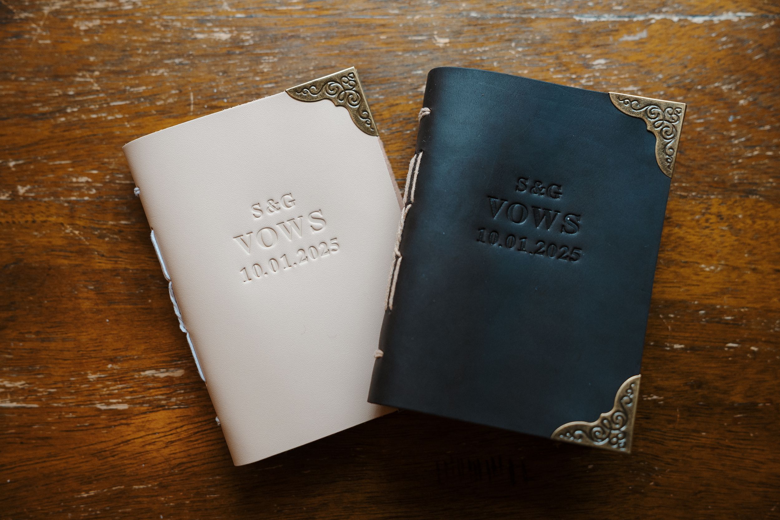 Small leather wallets in navy blue and white colors displayed on a rustic wooden surface.