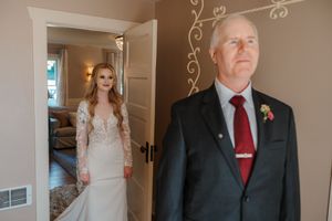 People in formal attire gathered in an elegant indoor setting with decorative wall details.