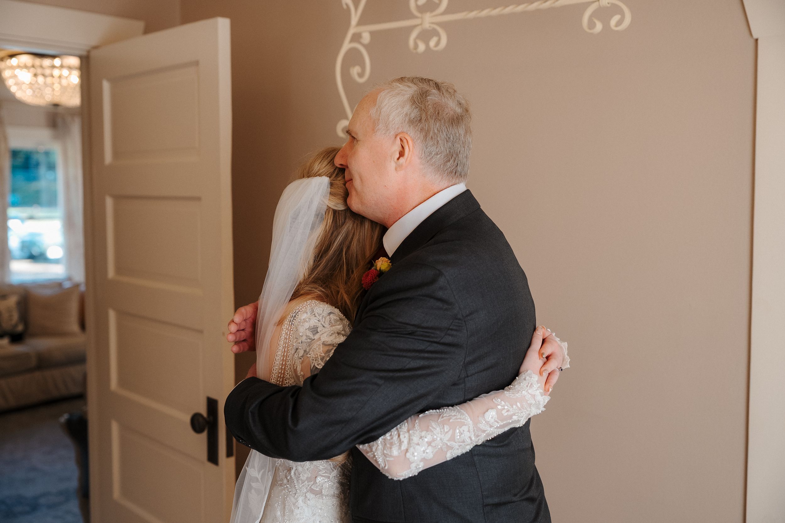 A couple embraces in a tender moment during their first look wedding reveal in an elegant indoor setting.