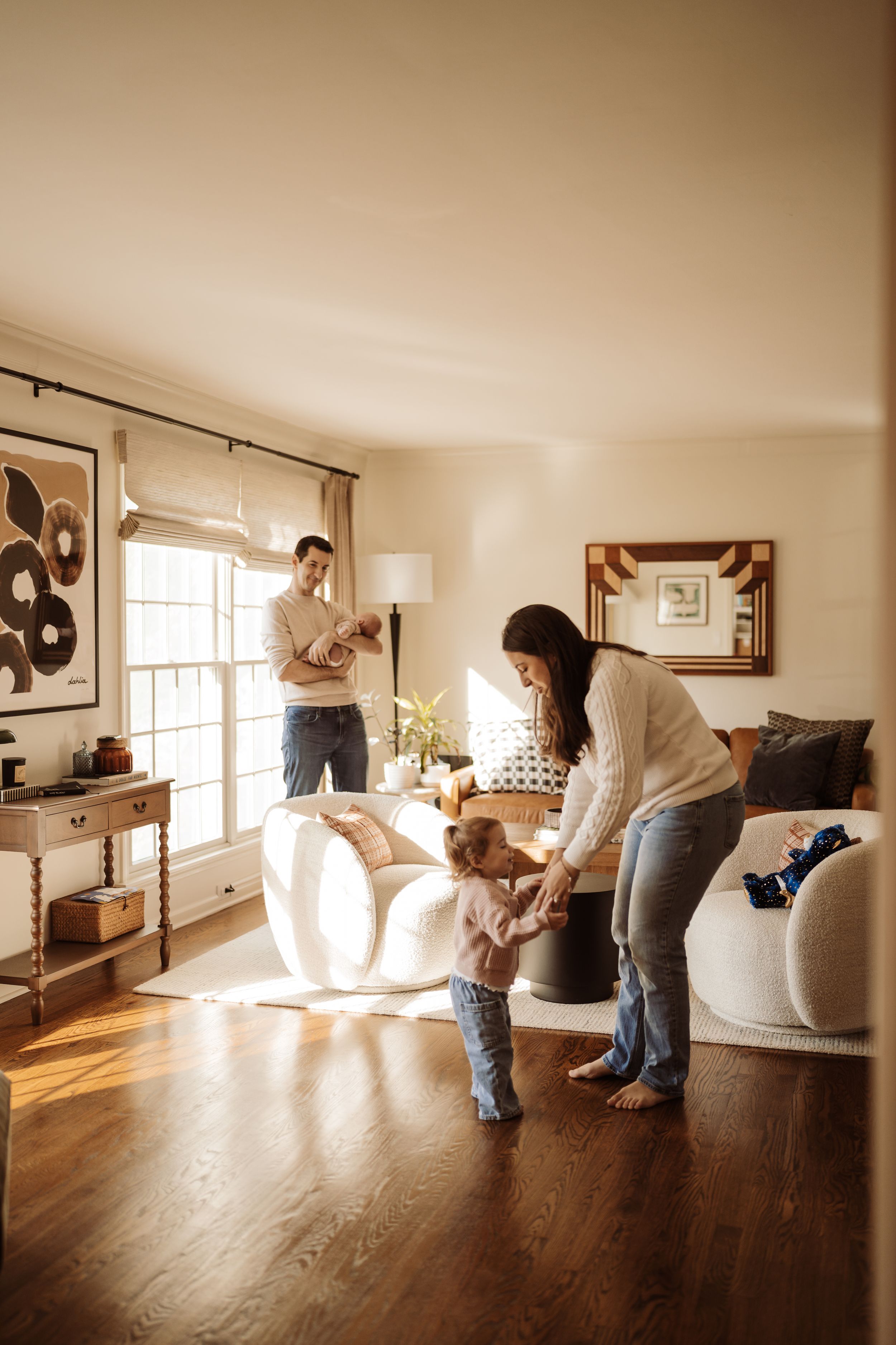 A sequence of photos showing someone moving a white couch through a sunlit room with hardwood floors.