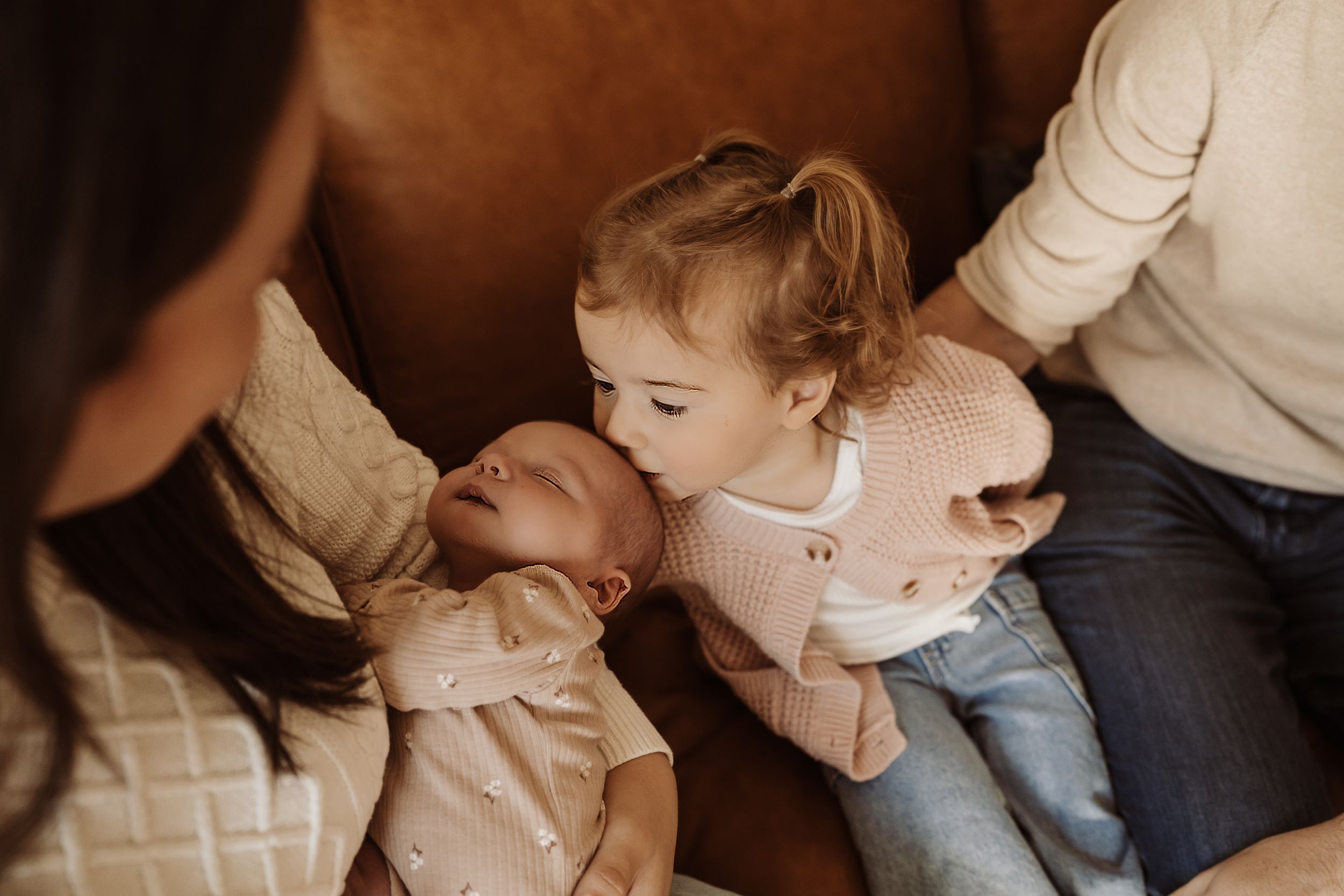 A series of intimate family moments captured in soft, warm lighting showing parents and child interacting.