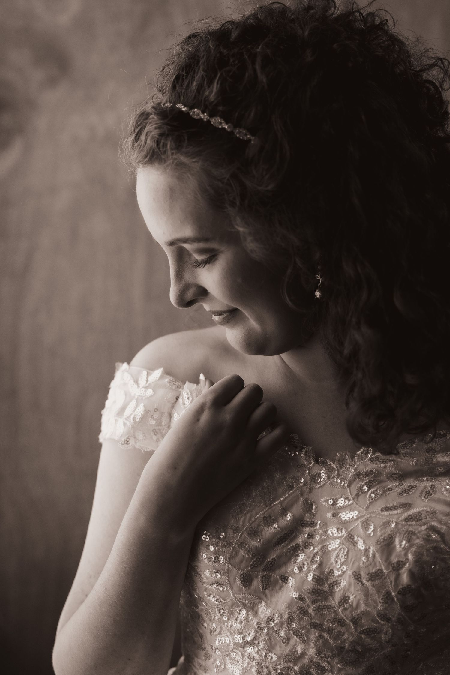 Artistic black and white portrait showing delicate lace detail on shoulder.