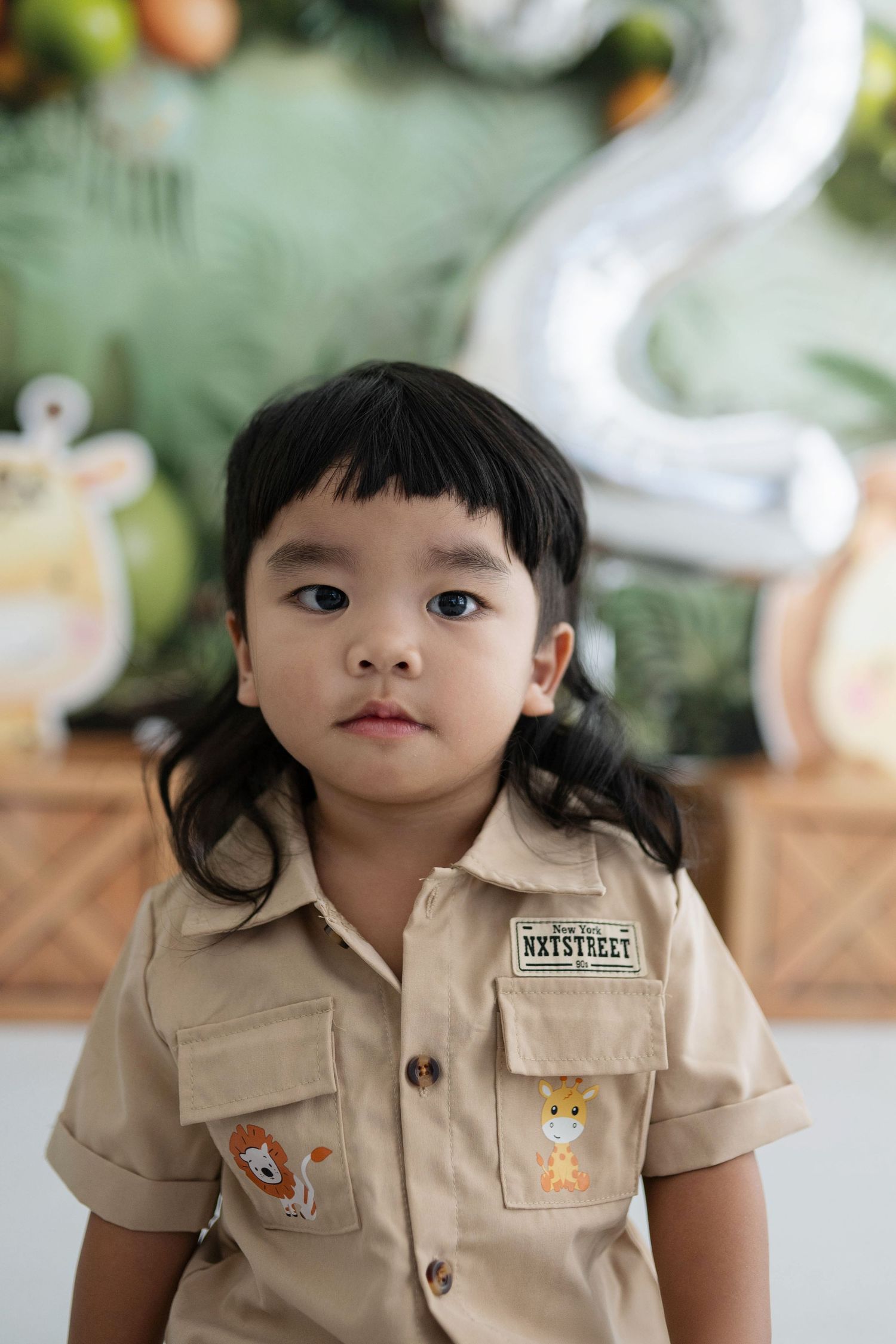 A series of photos showing a child in a tan uniform with animal patches and dark hair.