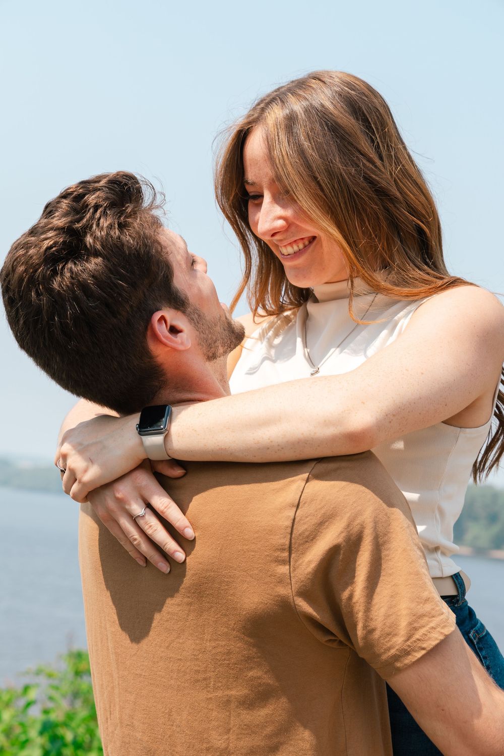 Two people sharing a romantic moment outdoors by the water, shown in a sequence of embracing photos.