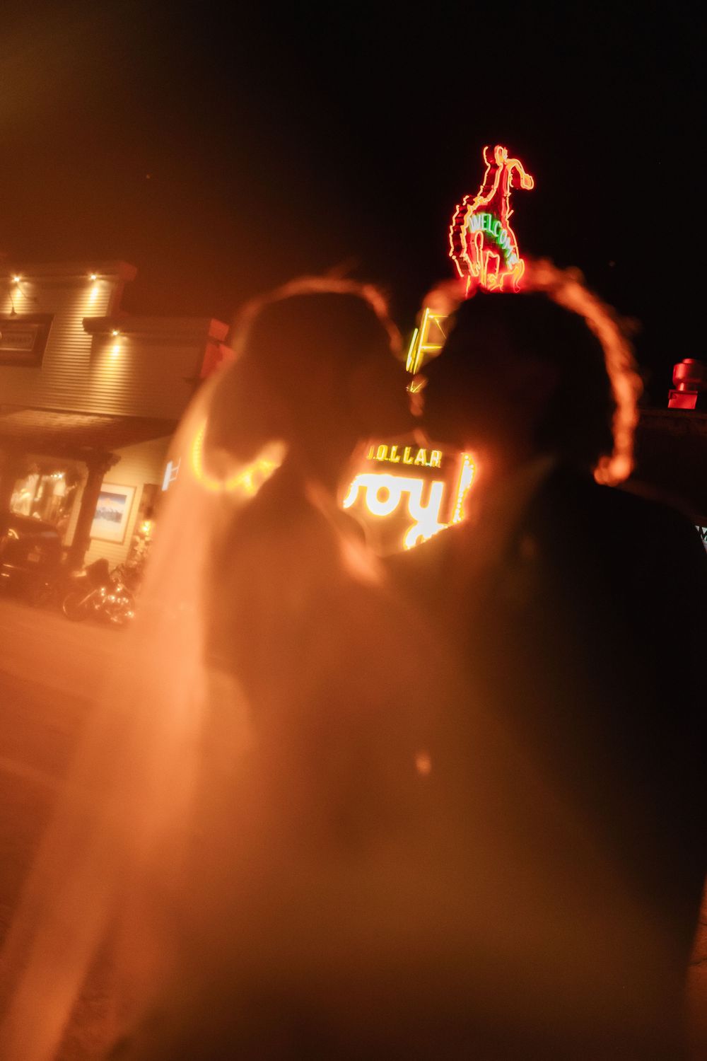 Glowing flames illuminate a nighttime performance with orange and red streaks through the darkness.
