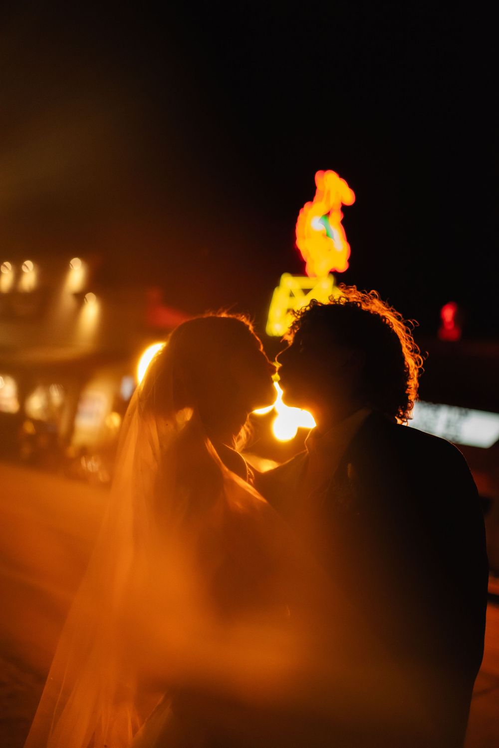 Fire performers create dramatic trails of light against a dark night sky during an outdoor entertainment show.