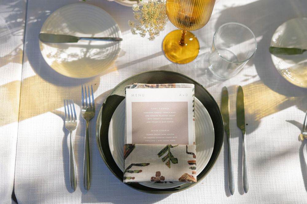 Elegant table settings with white linens, glassware and place settings at an upscale event.