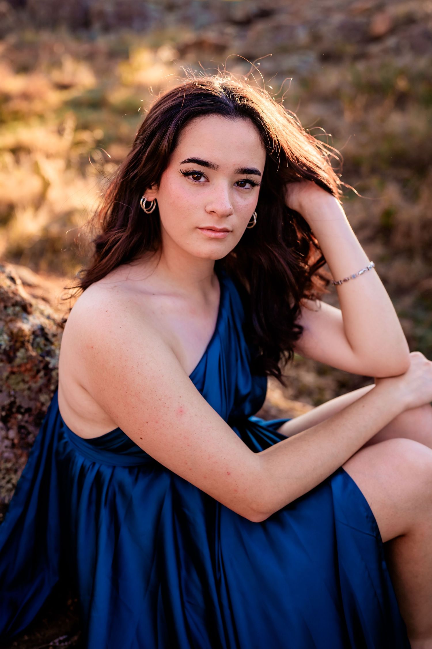 A series of outdoor portrait photographs featuring someone in a navy blue dress against a warm sunset backdrop.