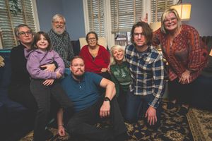 A group portrait of a diverse family sitting together in a cozy living room.