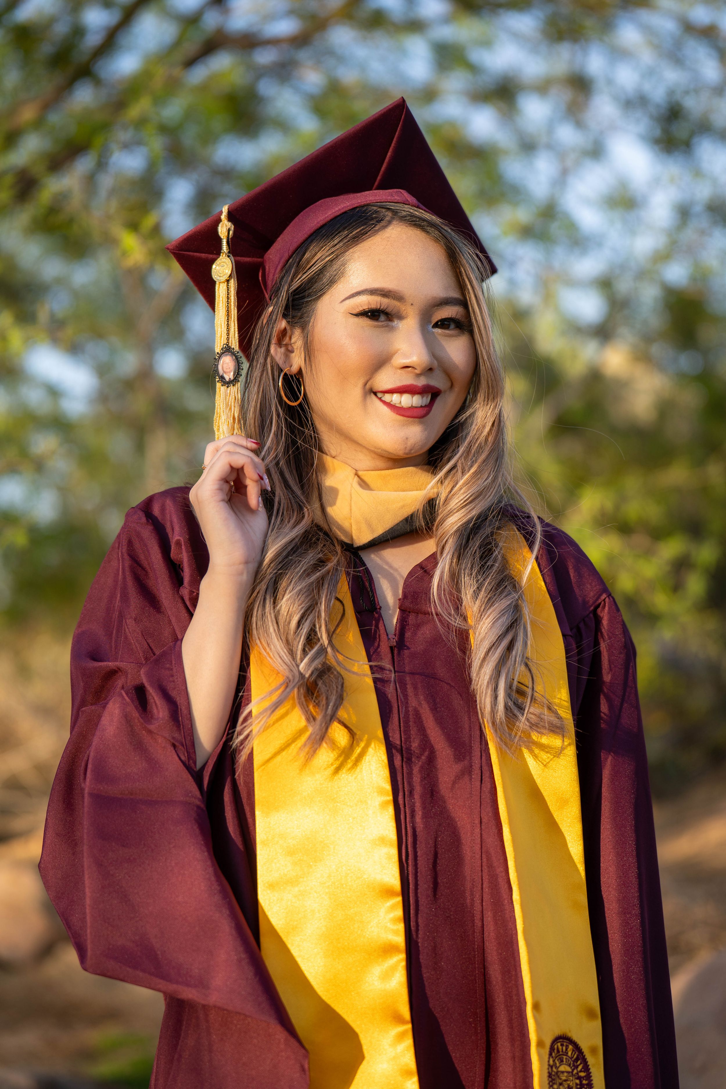 Arizona State University graduate pulling her tassel during a golden hour graduation shoot in Tempe, captured by N&D Media.