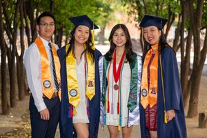 Four University of Arizona grad students posing together in graduation stoles and cords on campus by N&D Media Production.