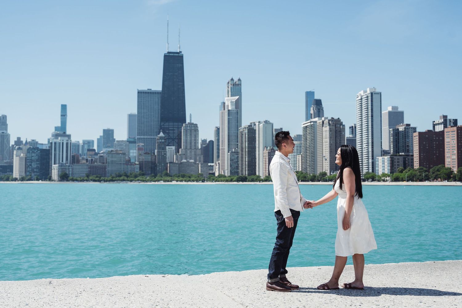 Chicago skyline panorama viewed across Lake Michigan with turquoise waters and clear blue skies.