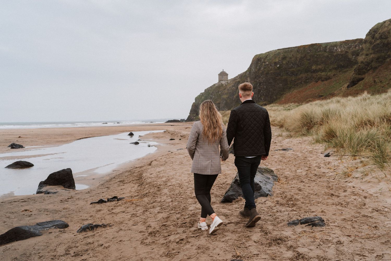Couple walking at Downhill beach, Northern Ireland