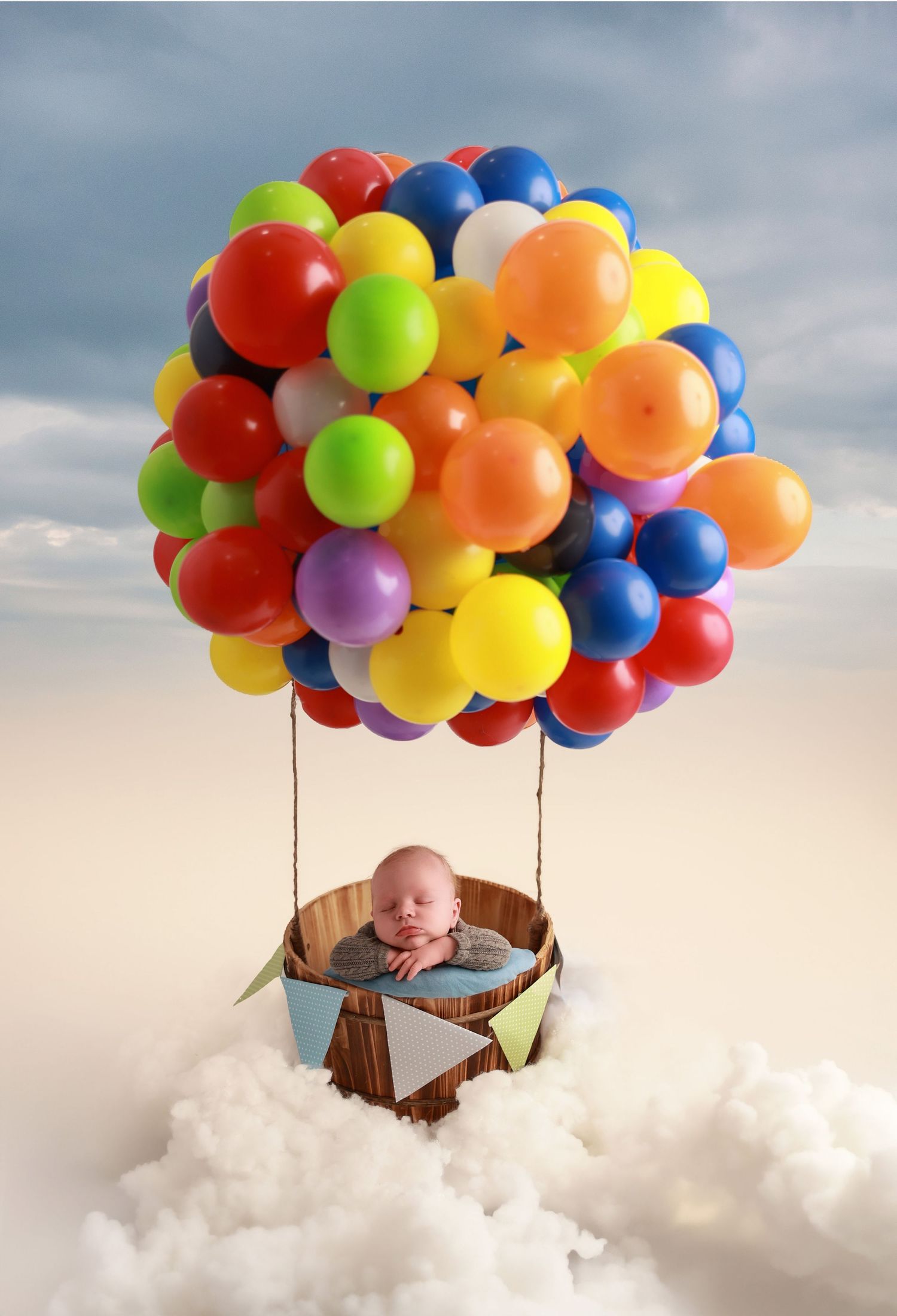 A sleeping baby in a basket floats through clouds suspended by colorful balloons in a dreamy composite photo series.