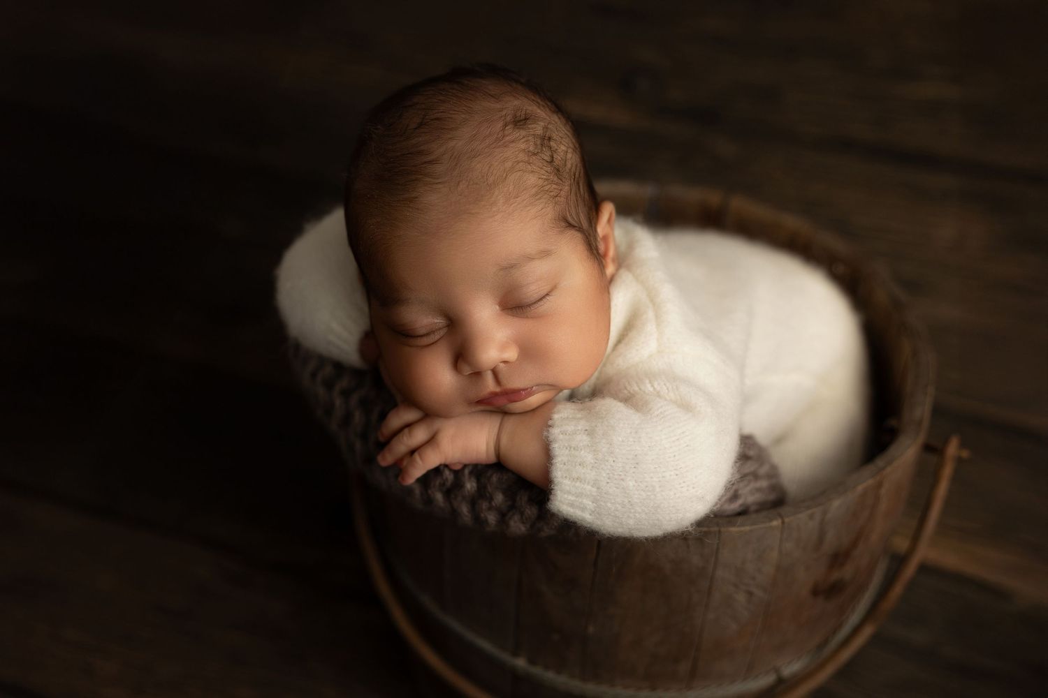 A series of professional newborn photography portraits showing a sleeping baby in various poses with soft lighting and props.