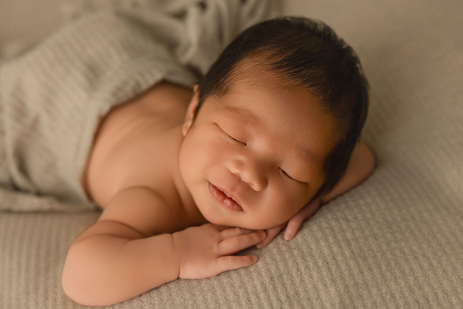 Artistic series of sepia-toned newborn portraits showing baby sleeping in neutral tones.