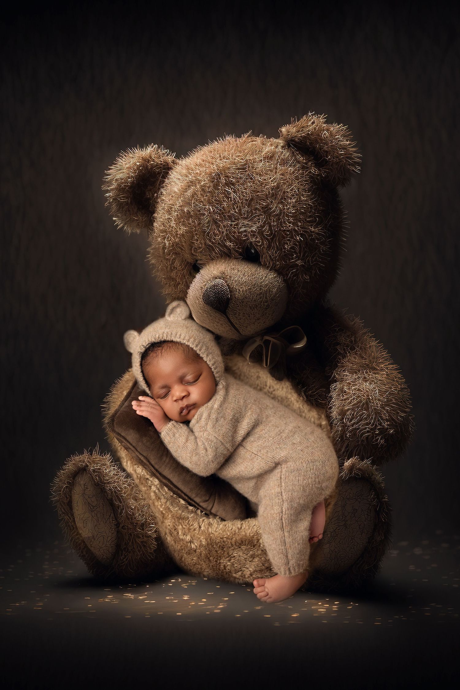 A series of artistic newborn photography poses with a large brown teddy bear against a dark background.