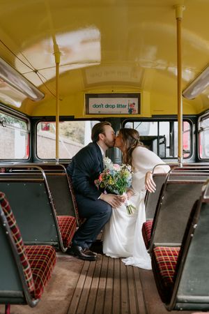 A romantic sequence of moments captured inside a vintage bus with plaid seats and wooden floors.