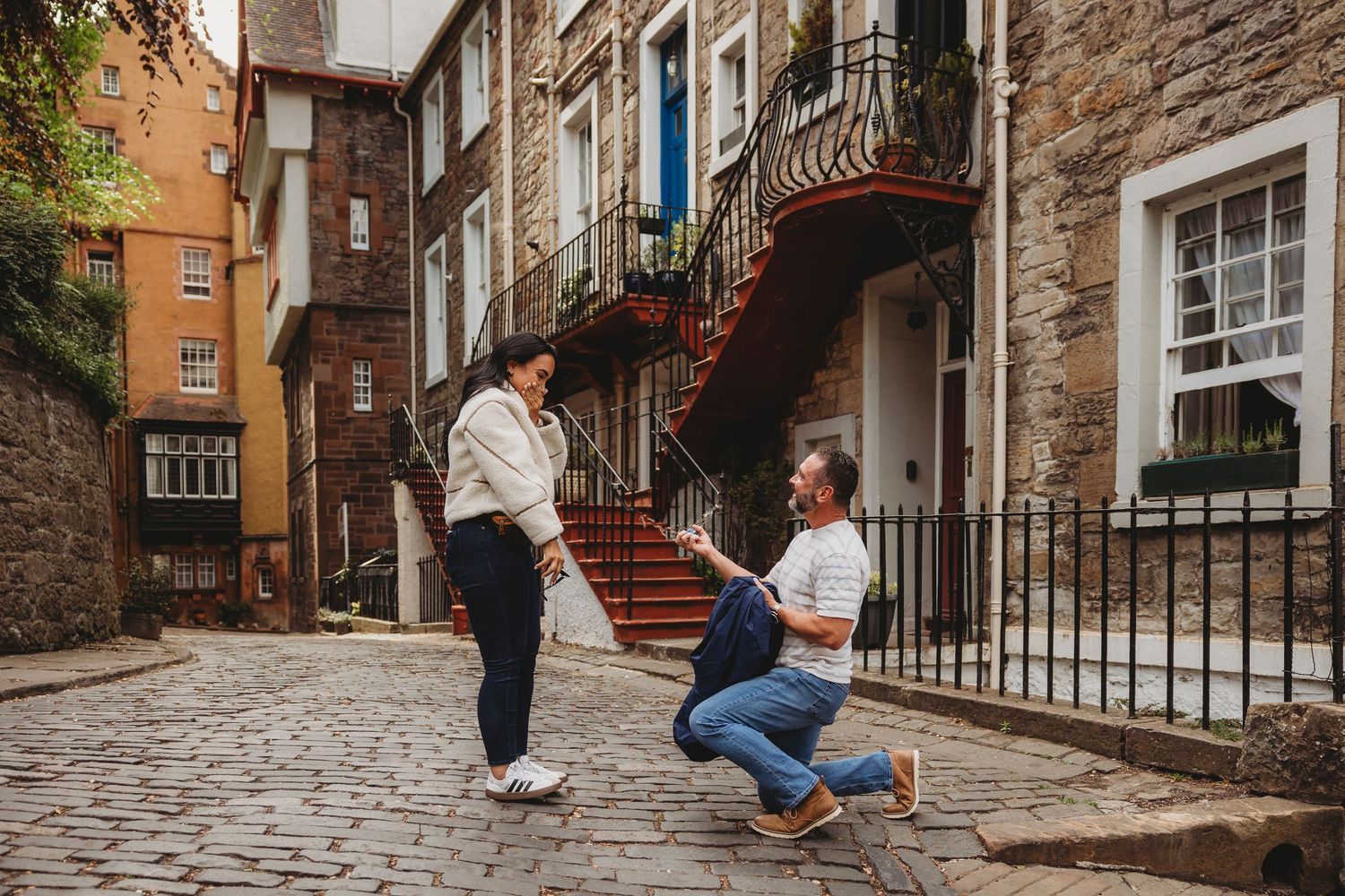 A couple poses on a cobblestone street in Quebec City's historic Petit-Champlain district during a romantic photoshoot.