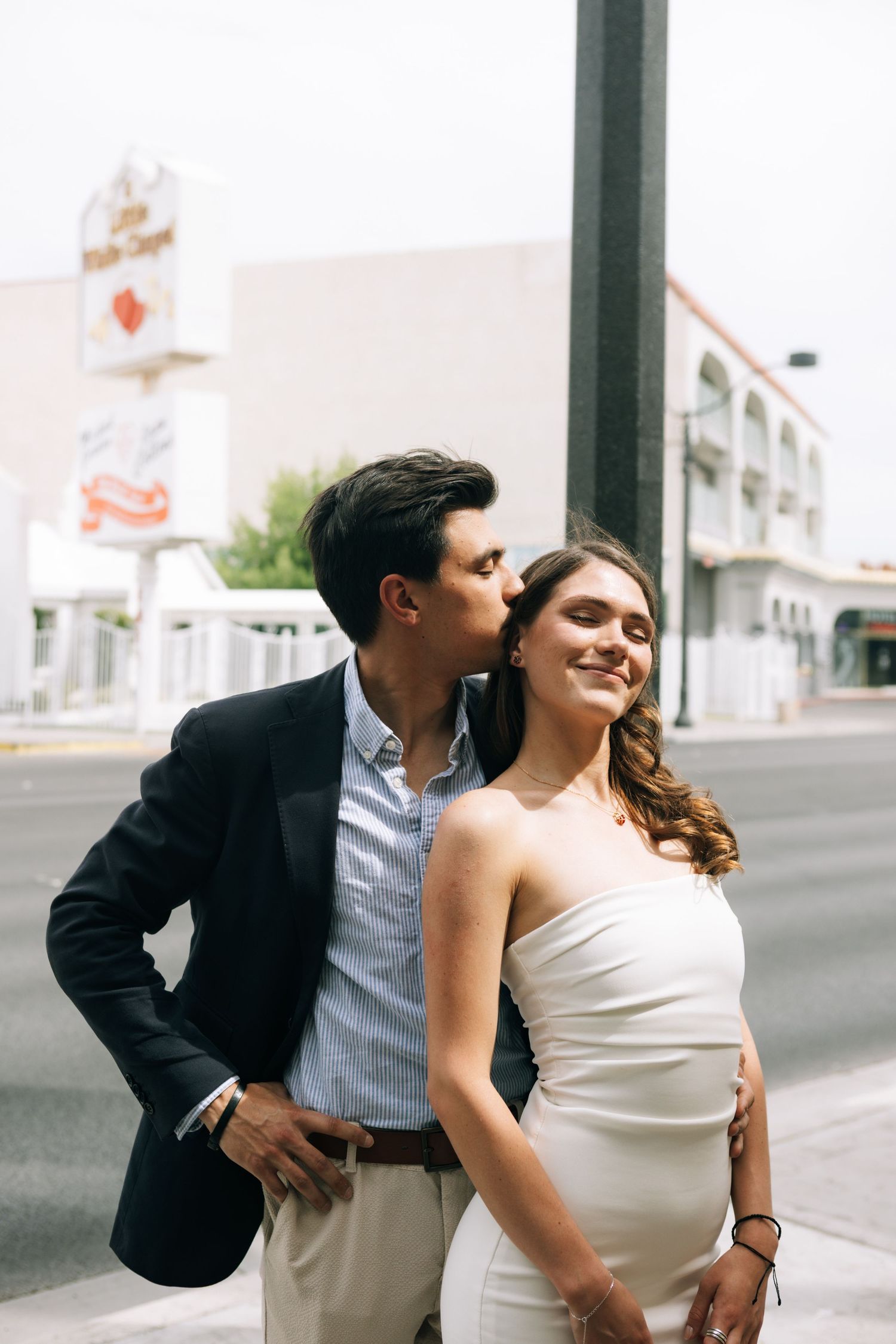 A romantic couple shares intimate moments in a series of candid photos on an urban street.