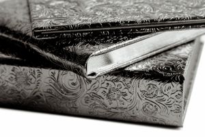 Close-up details of ornate silver engraving patterns on a vintage metal surface.
